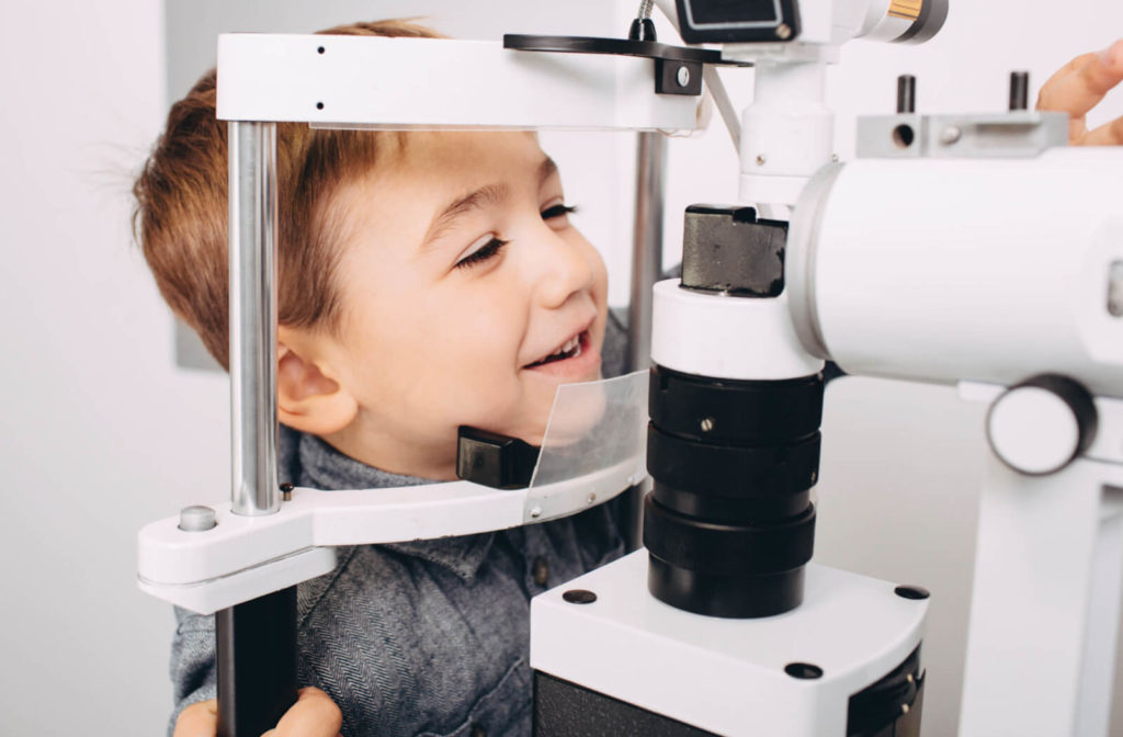 Close-up of a young boy looking into a machine that tests his vision.