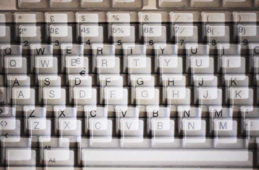 A close-up of a computer keyboard with a blurred, double-vision effect.