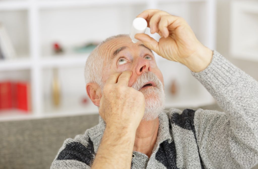 An older adult uses eye drops according to their eye doctor's recommendations on dosage and frequency.