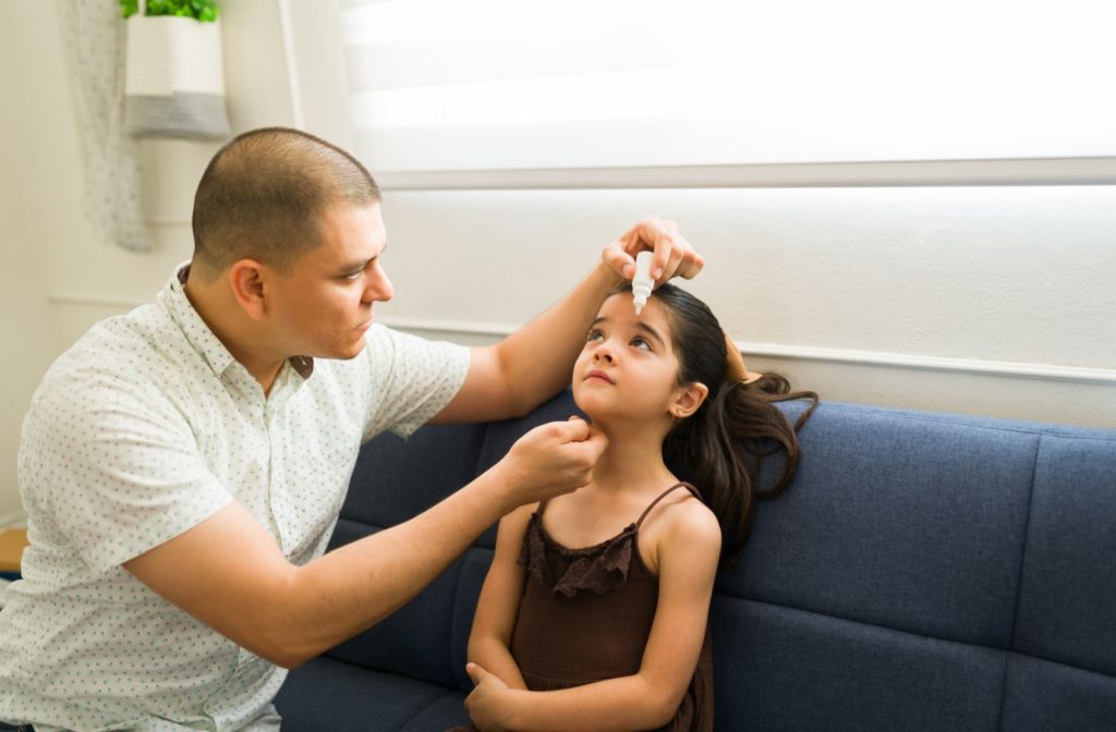  A parent helps their child apply eye drops according to their eye doctor's recommendations.