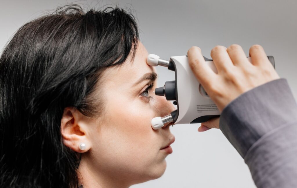 A person holds a device to their eye that measures eye pressure, a key factor in diagnosing glaucoma.
