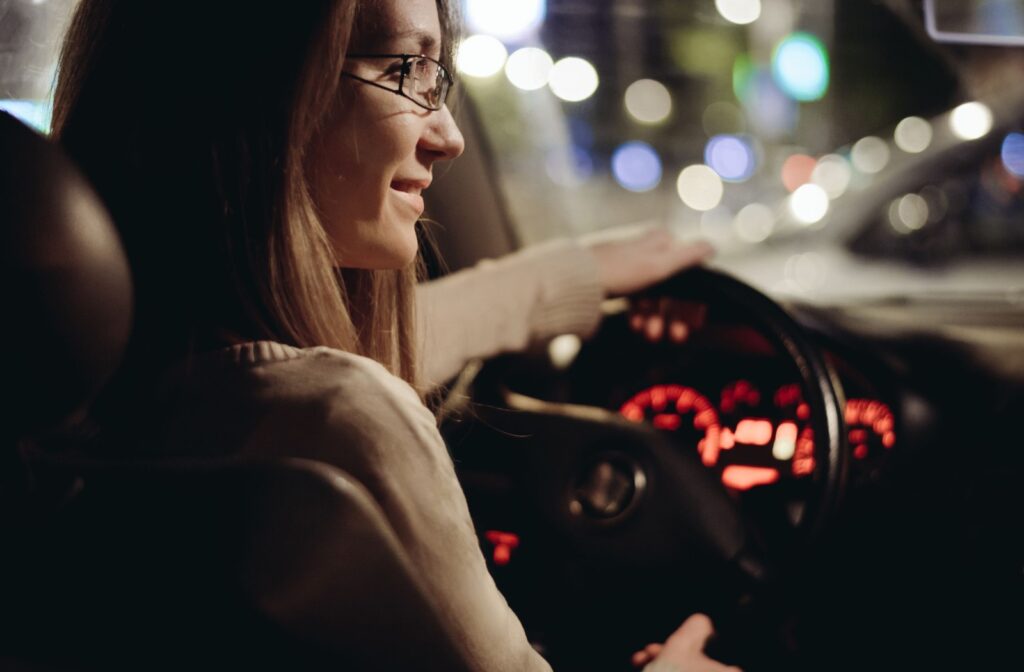 A person wearing glasses while driving at night to improve safety.